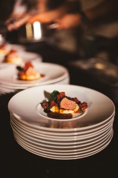 Elegantly plated gourmet dish on stacked plates presented in a fine dining setting.