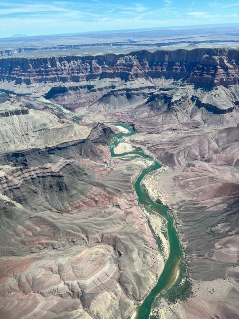 Stunning aerial view of the Grand Canyon showcasing the winding Colorado River under a clear sky