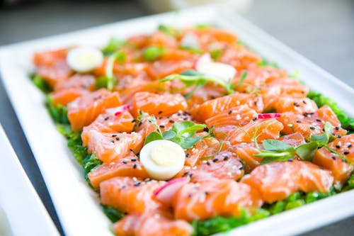 Salmon with greens and quail eggs on banquet table