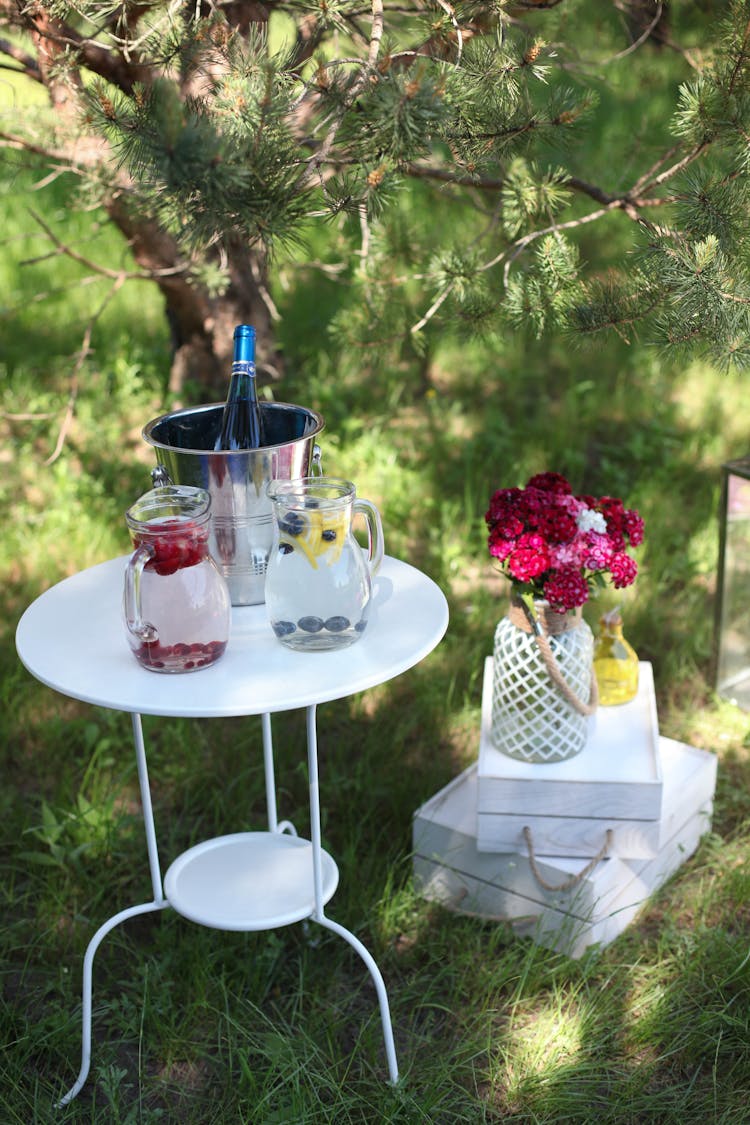 Garden Table With Refreshing Drinks And Flowers