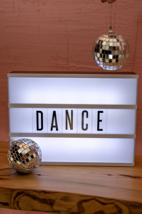 Miniature Disco Balls next to Lit up Sign