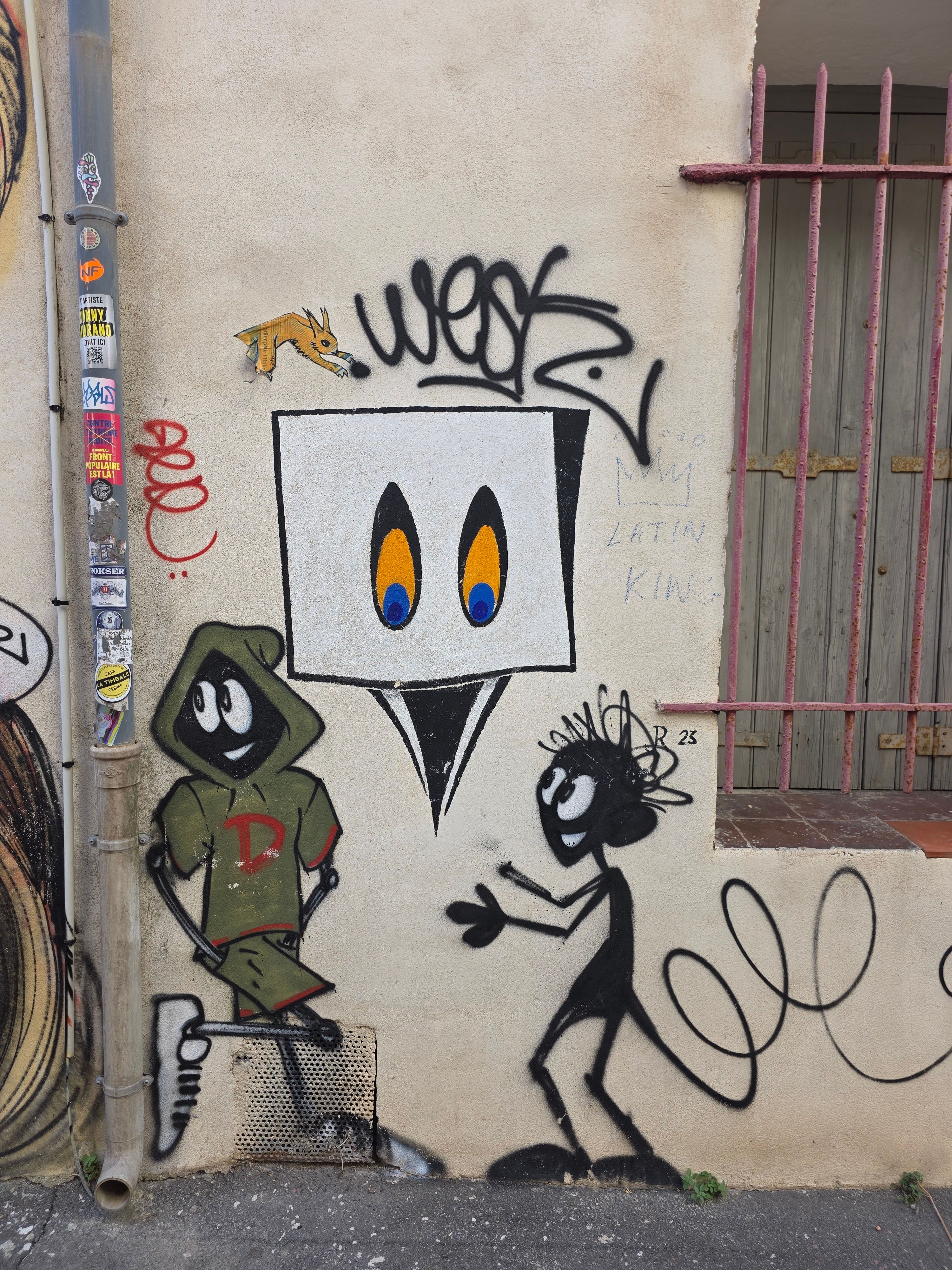Colorful graffiti art featuring expressive characters and abstract designs on a city wall.