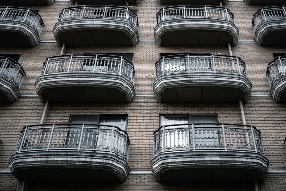 Symmetrical view of ornate balconies on a brick apartment building facade.