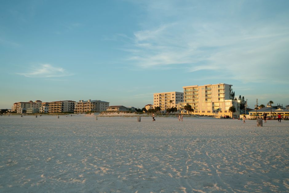 Serene beach scene during sunset with beachfront condos in the background.