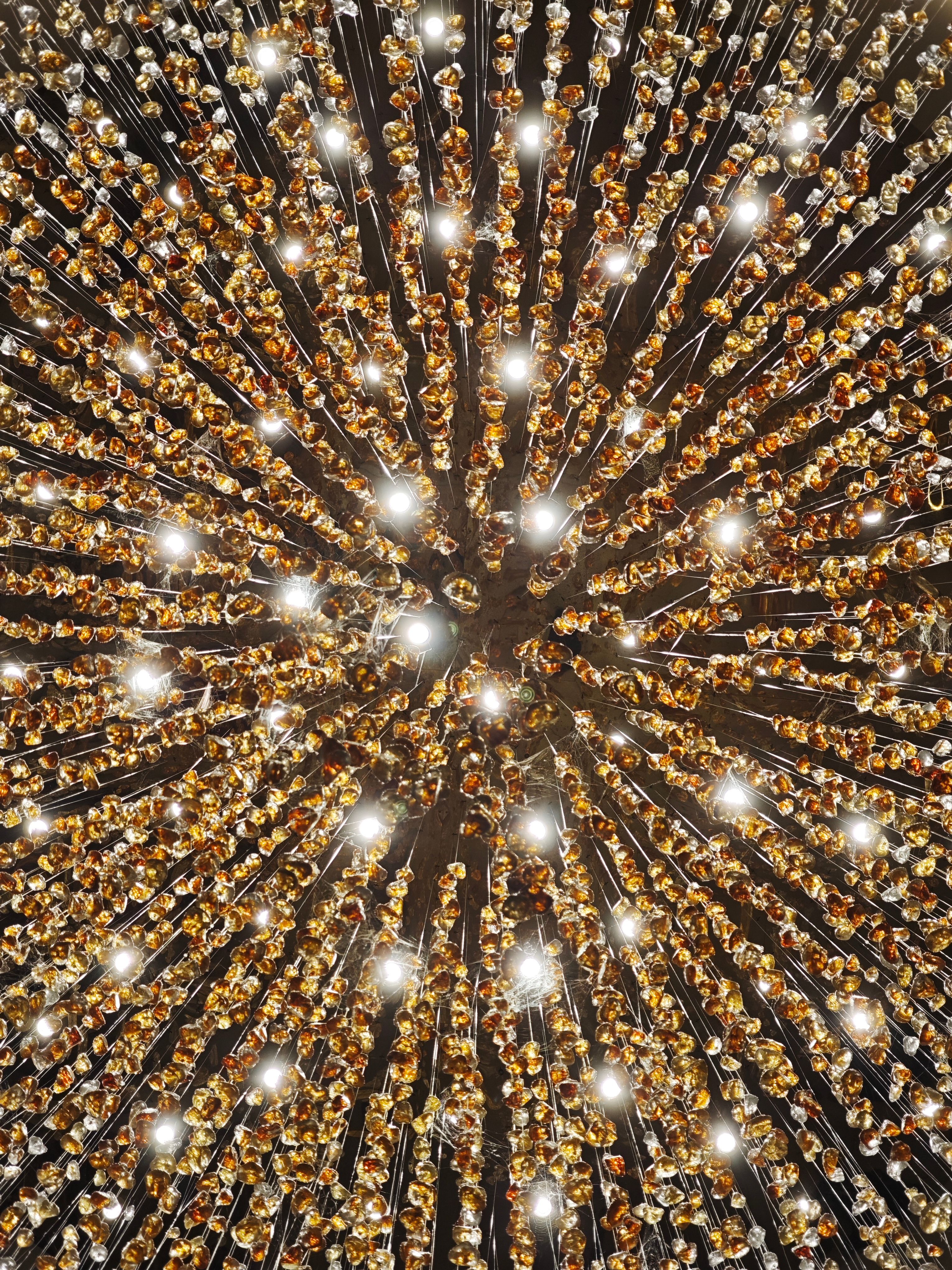 Stunning ceiling lights radiate a golden glow in a mesmerizing symmetrical pattern.