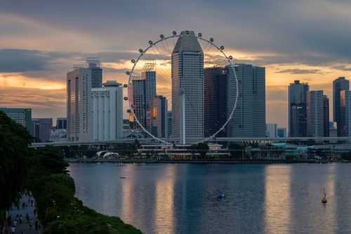 Free Stunning view of the Singapore skyline with the Ferris wheel at sunset, reflecting over Marina Bay. Stock Photo