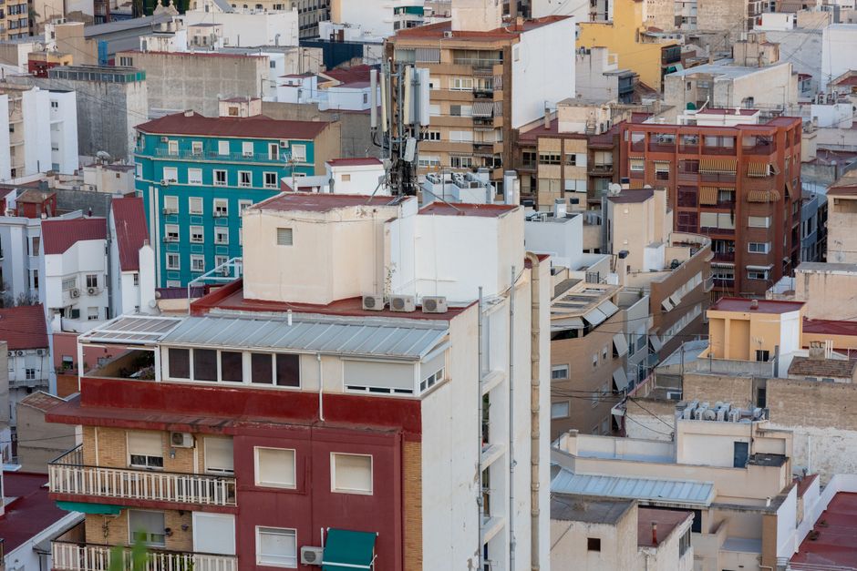 Vista aérea de tejados residenciales urbanos con edificios de colores vibrantes en el paisaje urbano.