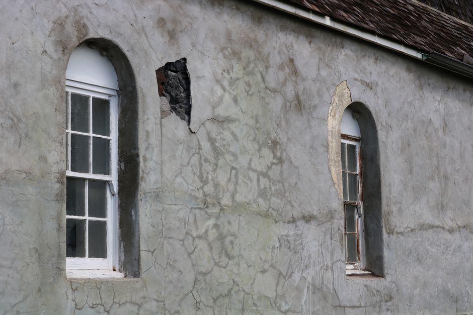 Photo by Deb Hayes on Pexels A cracked historic wall in Hawaii showing two arched windows.