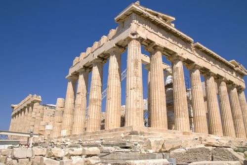 Free A view of the Parthenon in Athens showcasing its ancient Greek architecture against a bright blue sky. Stock Photo