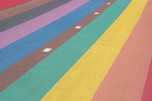 Free Vibrant rainbow-colored stripes painted on a pavement, ideal for abstract backgrounds. Stock Photo