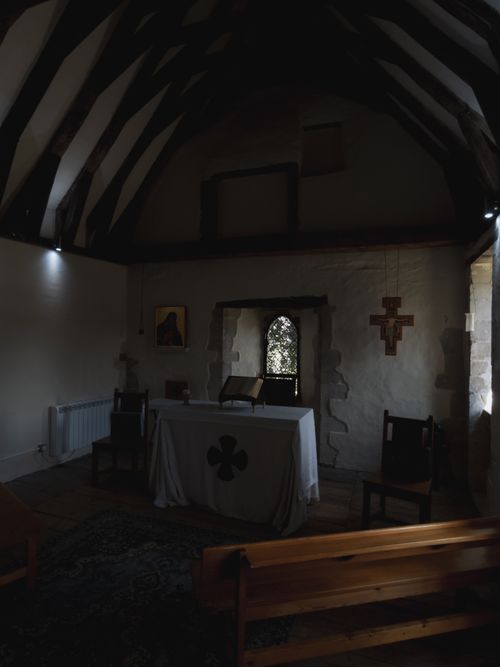 Free An inviting view of a small historic chapel with wooden beams and religious decor. Stock Photo