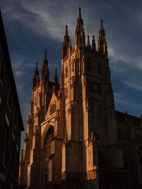 Free Beautiful Gothic cathedral facade illuminated by sunset against a dramatic sky, showcasing stunning architecture. Stock Photo