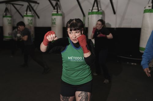 Free A focused female boxer trains at a Buenos Aires gym, showing power and determination. Stock Photo