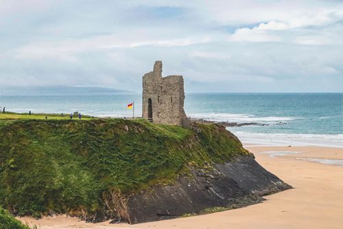 Free Historic Ballybunion Castle ruins atop green cliffs by the ocean in County Kerry, Ireland. Stock Photo