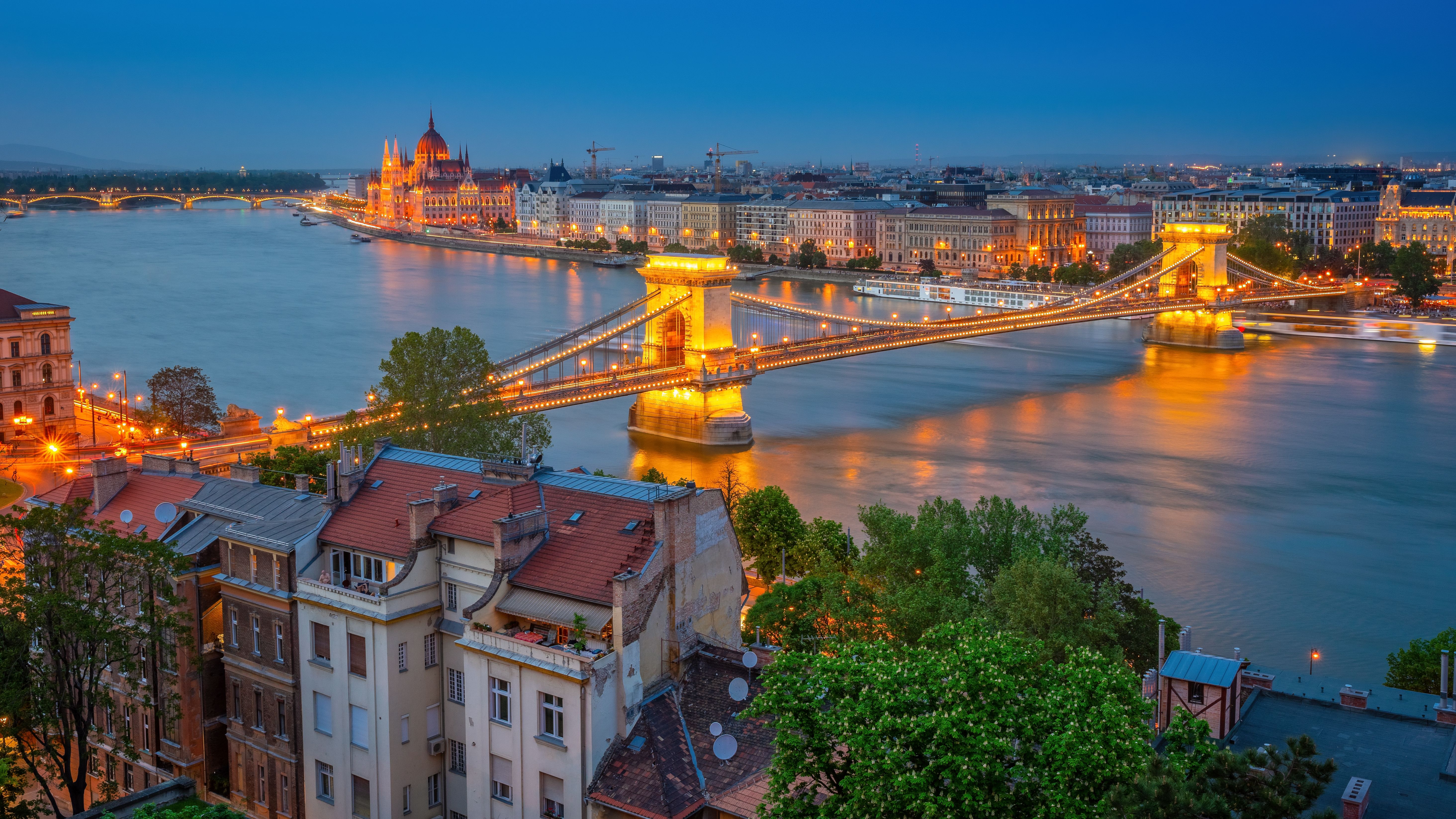 Beautiful view of Budapest's Chain Bridge and Parliament reflecting on the Danube River at night.