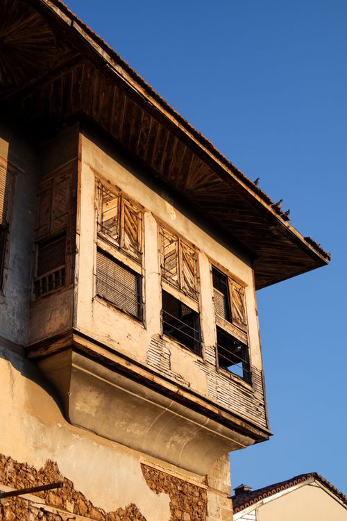 Free Detailed view of an old wooden house exterior with peeling paint under clear blue sky. Stock Photo
