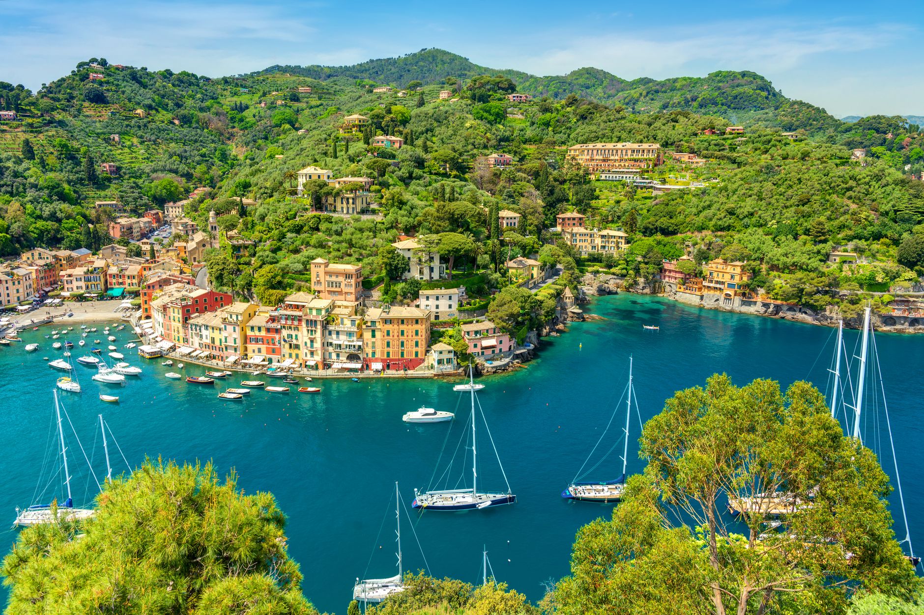 Veduta aerea di Portofino con yacht ormeggiati e vegetazione rigogliosa intorno al porto.