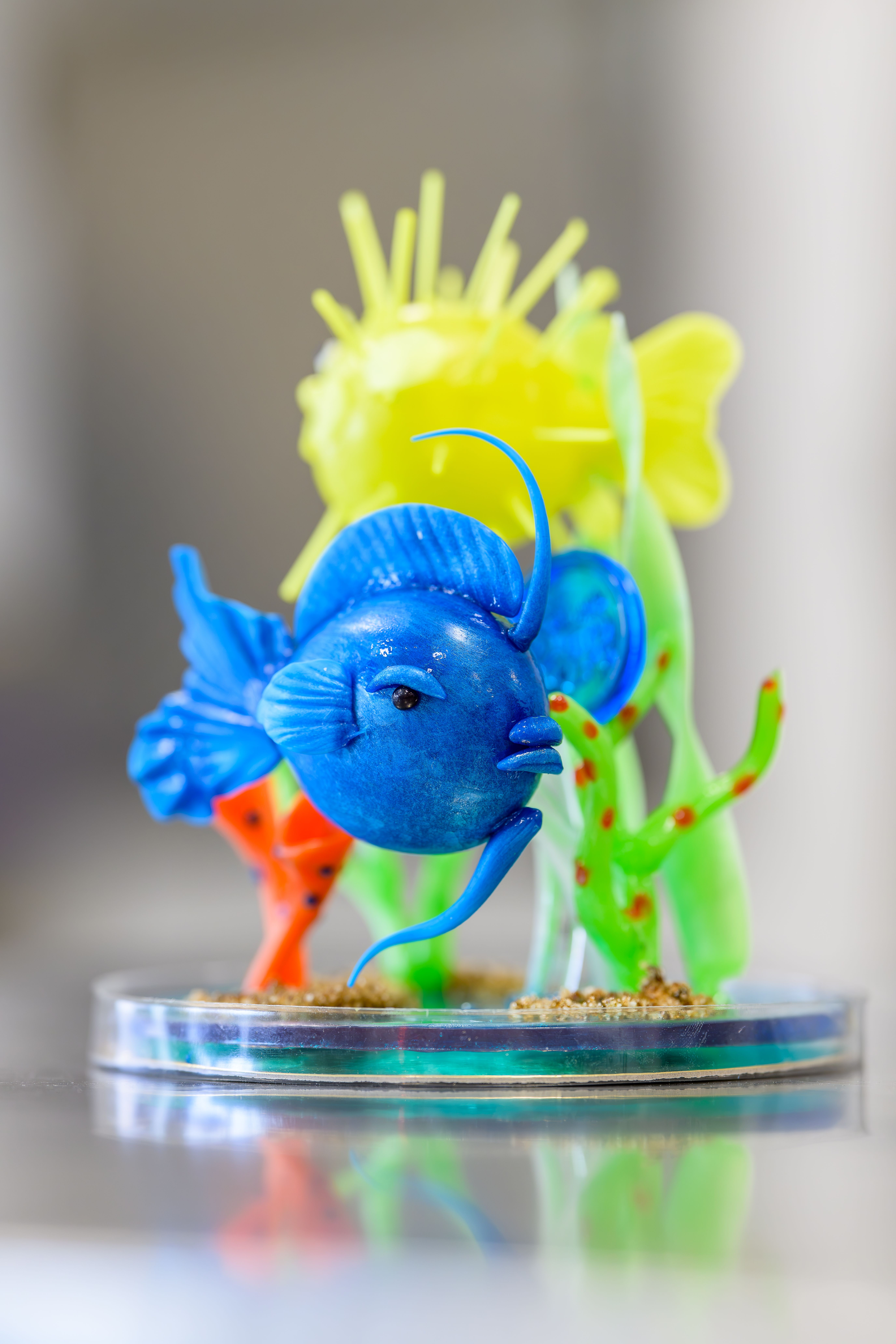 Intricate sugar art sculpture featuring a vibrant blue fish in an aquatic diorama.