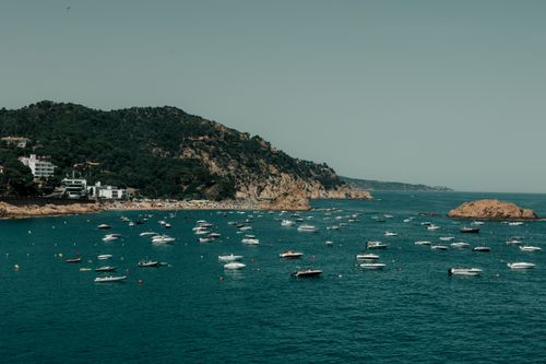 Free A picturesque view of boats dotting the azure waters along the scenic Tossa de Mar coastline. Stock Photo