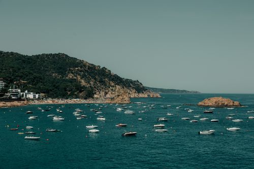 Free A beautiful coastal view of boats in the turquoise waters of Tossa de Mar, Cataluña, Spain. Stock Photo