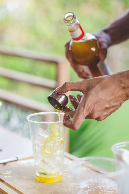 Free Bartender pouring whiskey into a glass with ice outdoors. Stock Photo