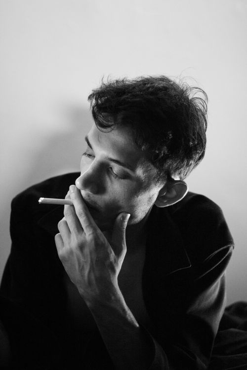 Free Dramatic black and white portrait of a man smoking, showcasing deep thought. Stock Photo