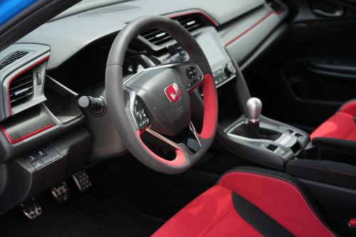 Free Close-up of the red and black interior of a Honda sports car with a focus on the steering wheel. Stock Photo