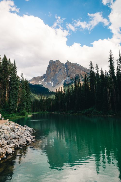 Free Tranquil lake with the Canadian Rocky Mountains in the background, perfect for nature and travel enthusiasts. Stock Photo