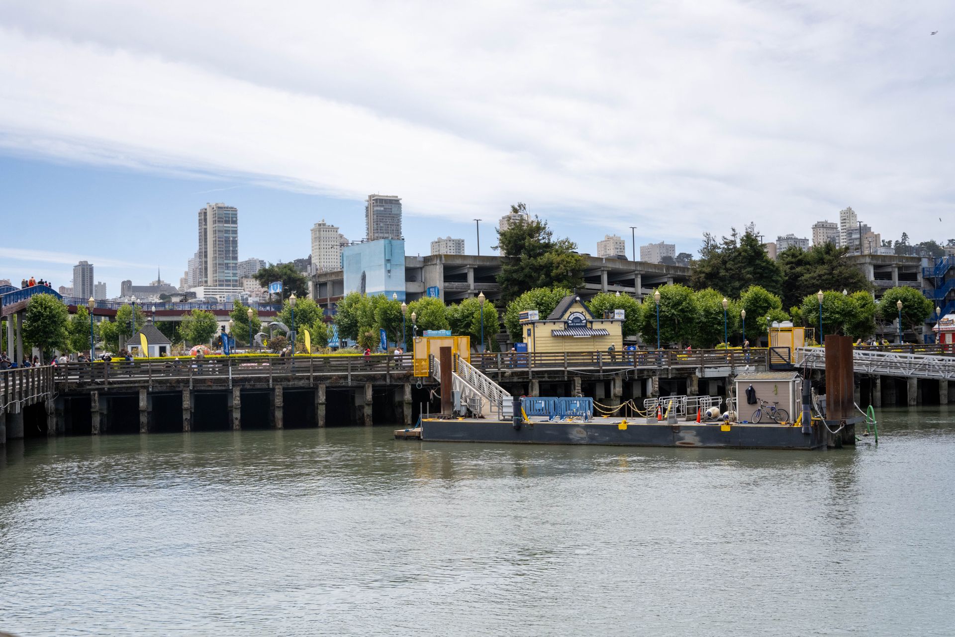 San Francisco waterfront at the Embarcadero with piers, boats, downtown skyline, and bay waters in daylight