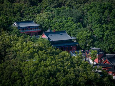 An exquisite aerial view of a historic Asian temple nestled within dense, vibrant greenery.