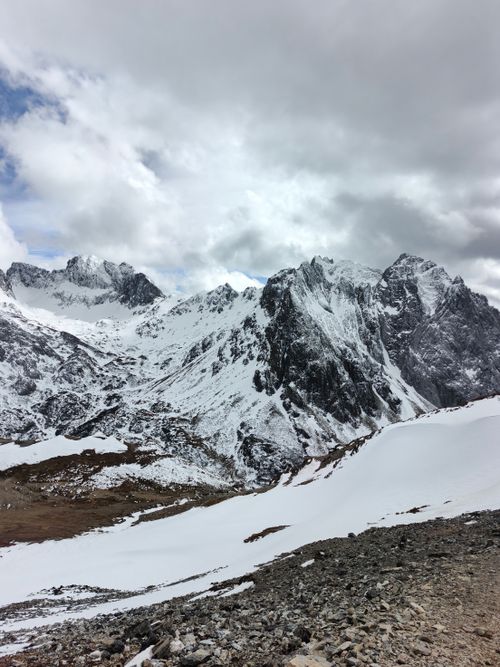 Free Majestic snow-covered mountains with dramatic clouds above, offering a breathtaking view. Stock Photo