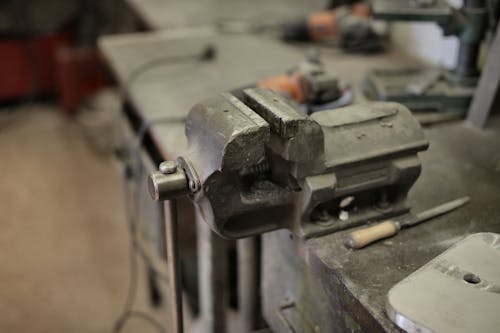 From above of vise fixing at workbench among different tools in workshop