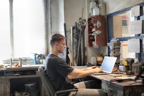 Koncentruje Się Mężczyzna Pracuje Na Laptopie W Warsztacie