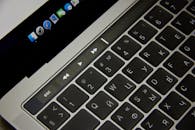 特写镜头展示了笔记本电脑键盘上的俄语字母和触摸条，置于现代环境中