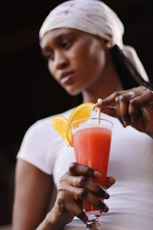 Free A woman enjoying a cool, refreshing summer drink garnished with orange slices. Stock Photo