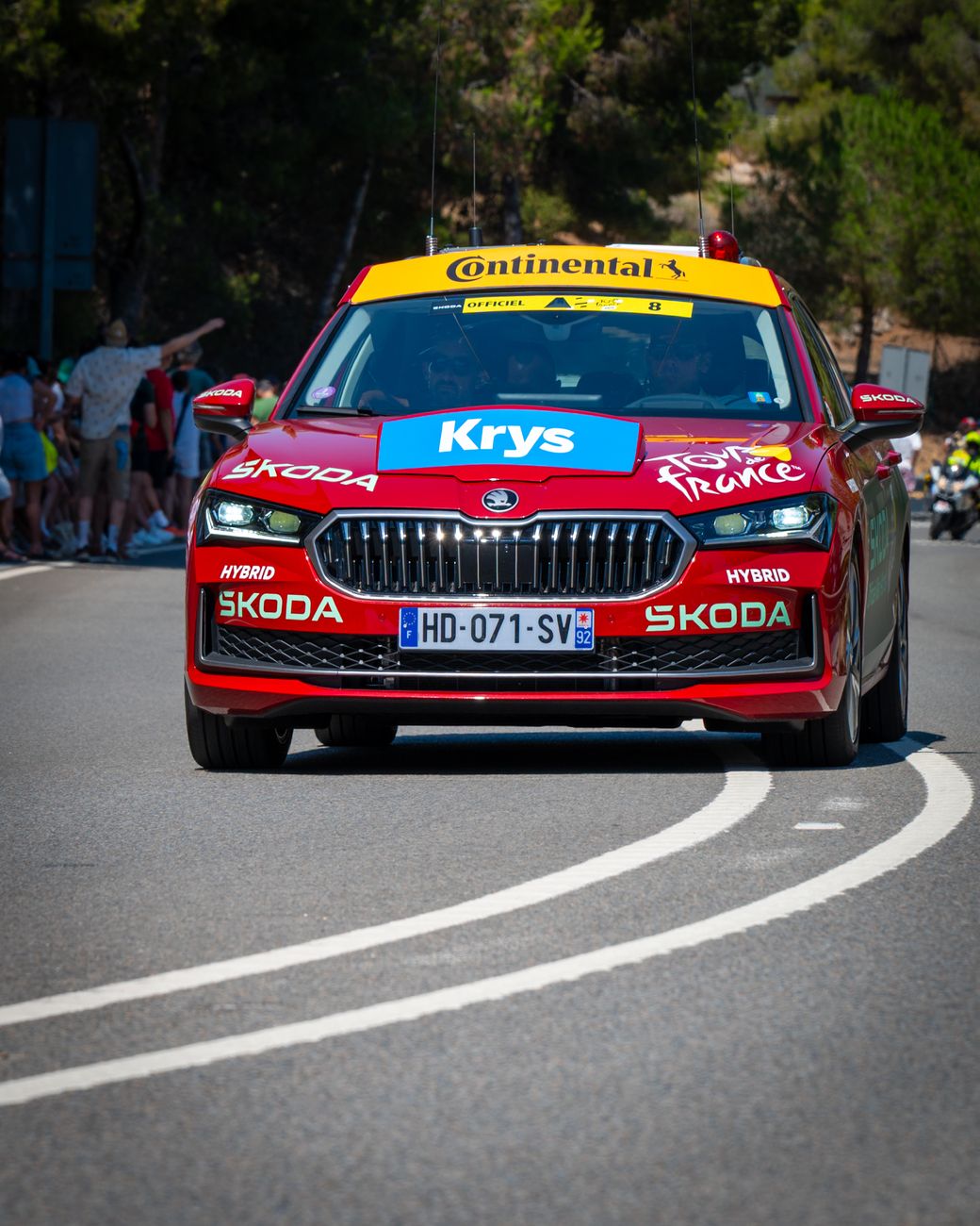 Een rode Skoda die deelneemt aan de Tour de France, gefotografeerd in de buitenlucht overdag.
