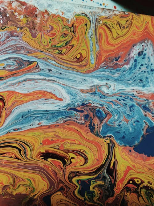 Abstract background of chaotic waves painted in different shades of blue and orange colors