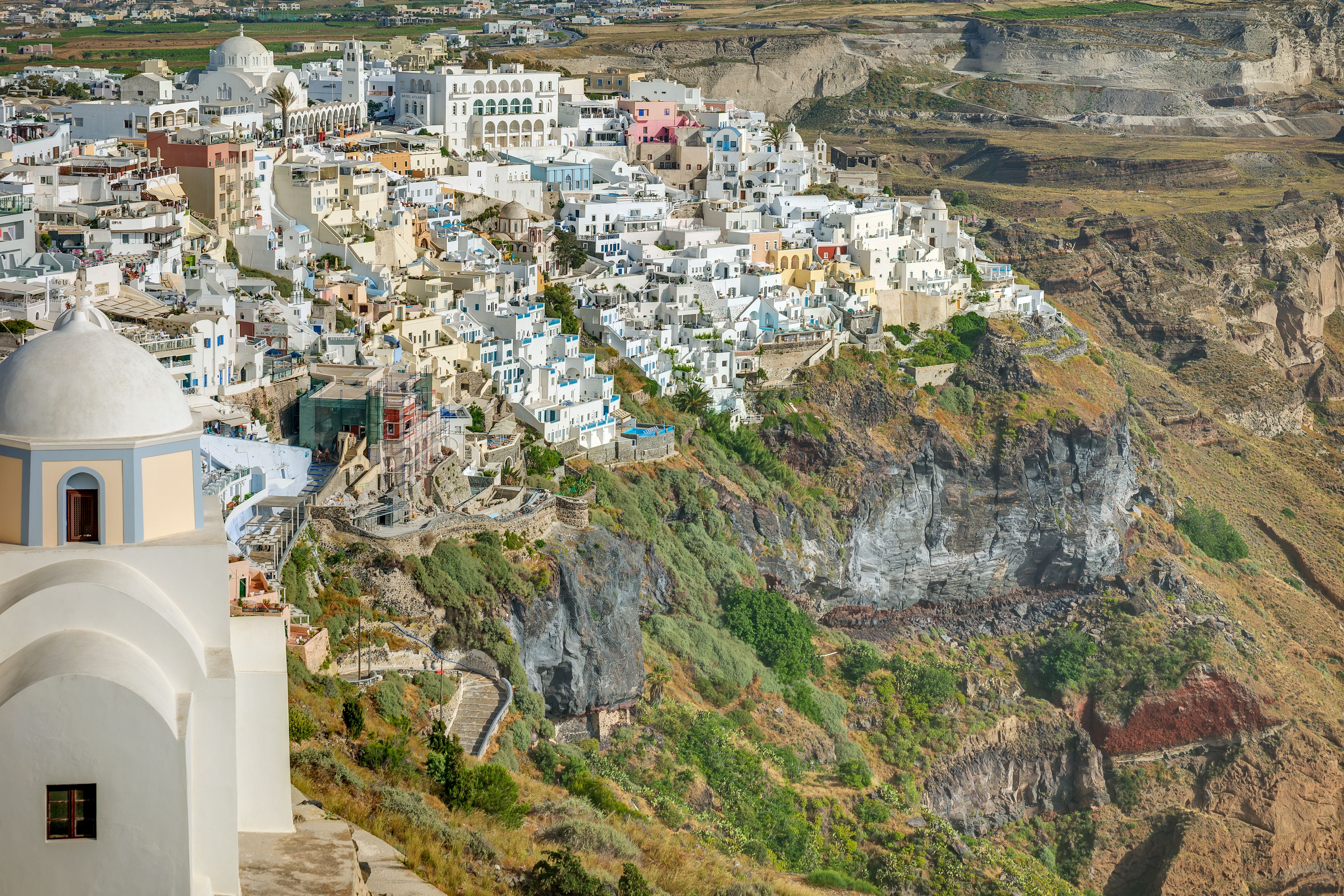Breathtaking view of Fira town perched on Santorini's cliffs, showcasing whitewashed buildings and stunning landscapes.