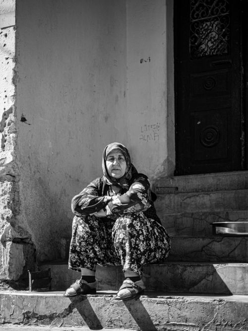 Free Black and white photo of a woman resting on stone steps outdoors, conveying a timeless and contemplative mood. Stock Photo
