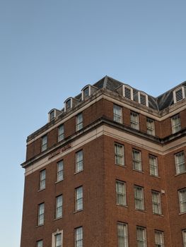 Brick building facade of Victoria House in Birmingham, UK, under clear blue sky.