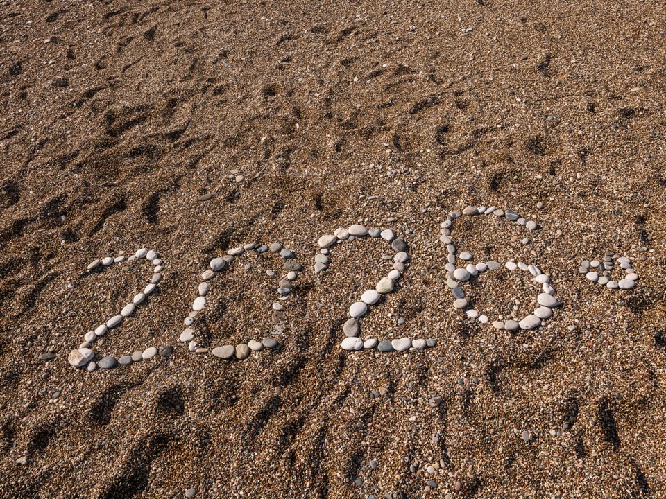 Stones arranged to form the number 2026 on a sandy coastline, creating a natural and creative scene.