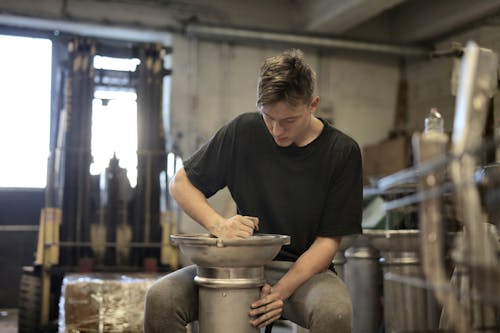 Man in Black Crew Neck T-shirt Holding Gray Steel Bucket