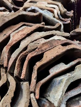Close-up of aged, stacked roofing tiles showcasing texture and detail.