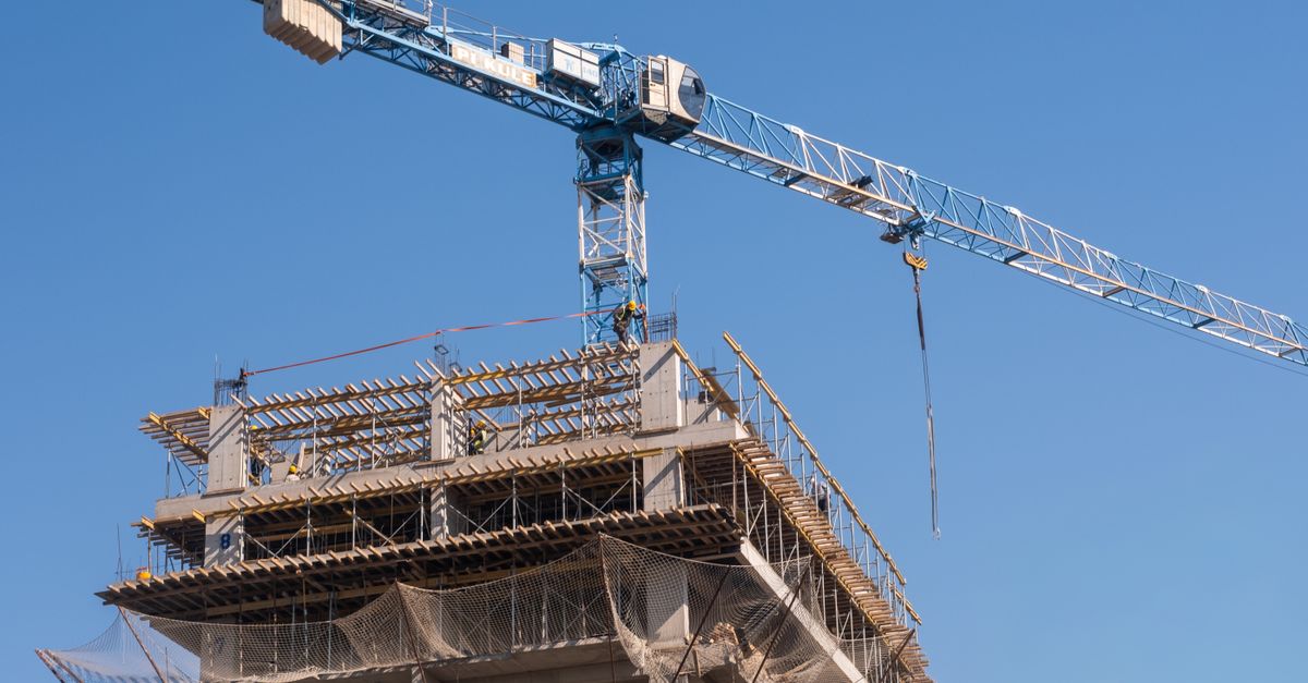 Tower crane and building structure in progress at a construction site in İzmir, Türkiye.