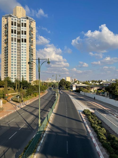 Free Clear day cityscape of an empty road alongside a high-rise building in Israel. Stock Photo