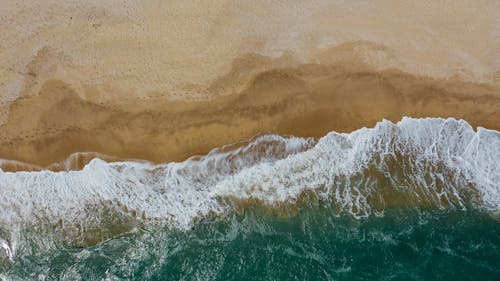 Brown Sand Beside Body of Water