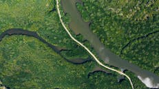 无人机拍摄下，蜿蜒的河流被茂密的绿色森林环绕，展现了大自然的美丽