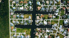 无人机镜头下，郊区运河旁的房屋排列整齐，水道清澈