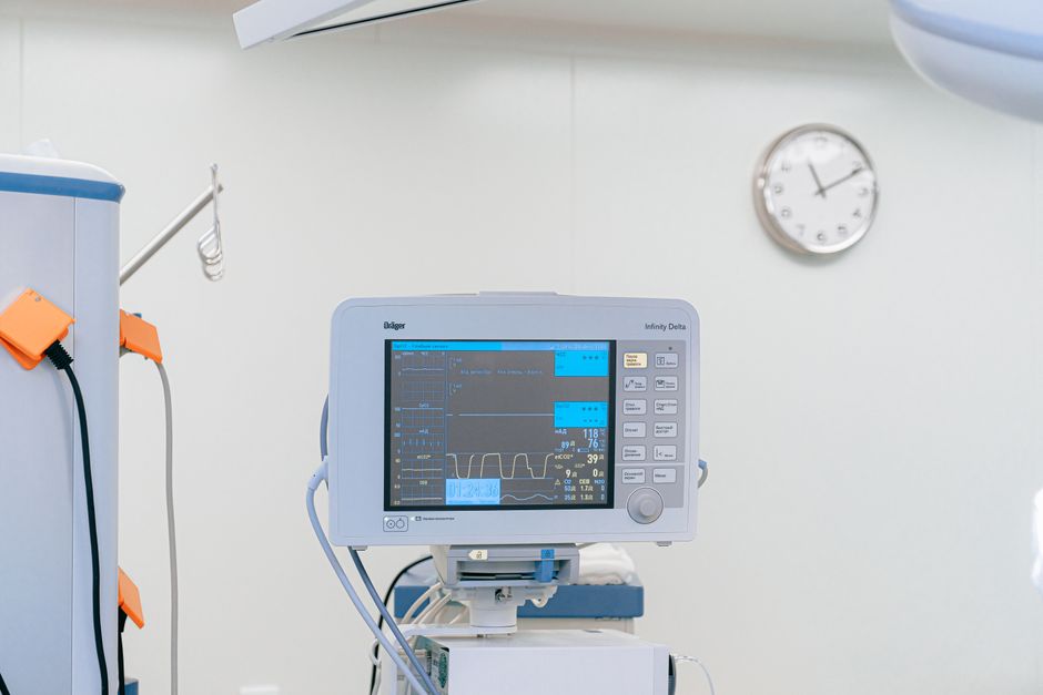 Heart rate monitor displaying vital signs in a clinical setting — EKG and cardiovascular assessment are required before any iboga ceremony due to ibogaine's cardiac effects