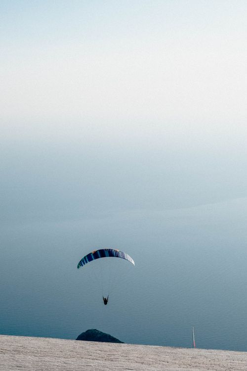 Free Soaring paraglider over the serene Ölüdeniz sea in Turkey, showcasing adventure and tranquility. Stock Photo